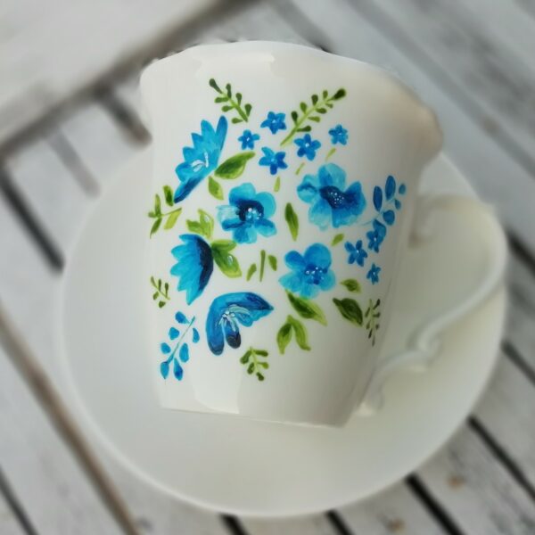 hand made ręcznie malowana biała porcelanowa filiżanka ze spodkiem namalowane niebieskie kwiaty i listki